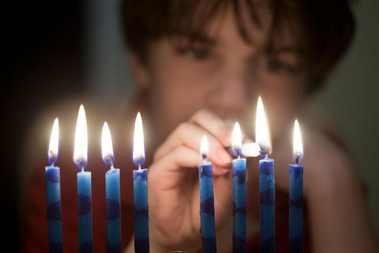 Boy lighting Chanukah candles
